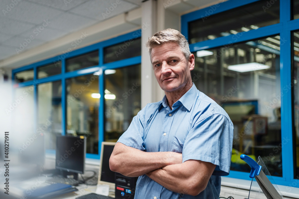 Mature male entrepreneur with arms crossed in factory office Mature male entrepreneur with arms crossed in factory office