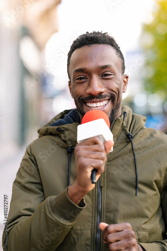 Close-up of smiling male presenter talking over microphone