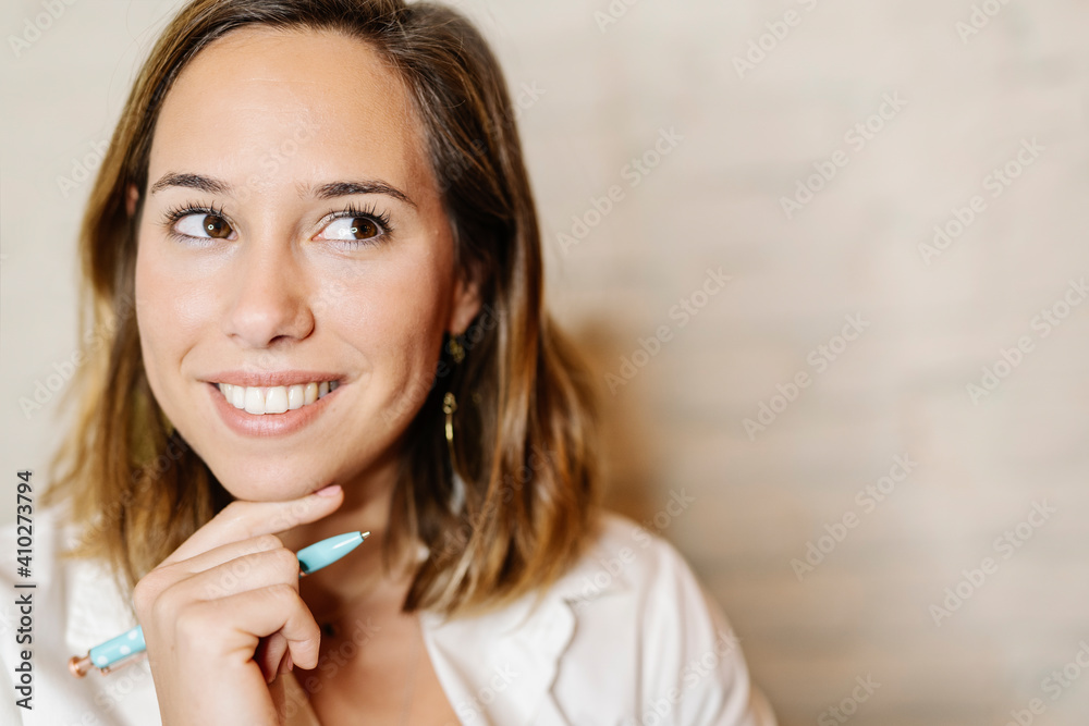 Close-up of thoughtful businesswoman looking away against wall Close-up of thoughtful businesswoman looking away against wall