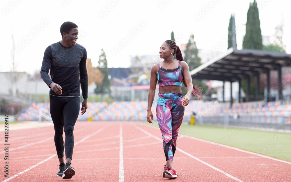 Male and female sportsperson walking on track against clear sky Male and female sportsperson walking on track against clear sky