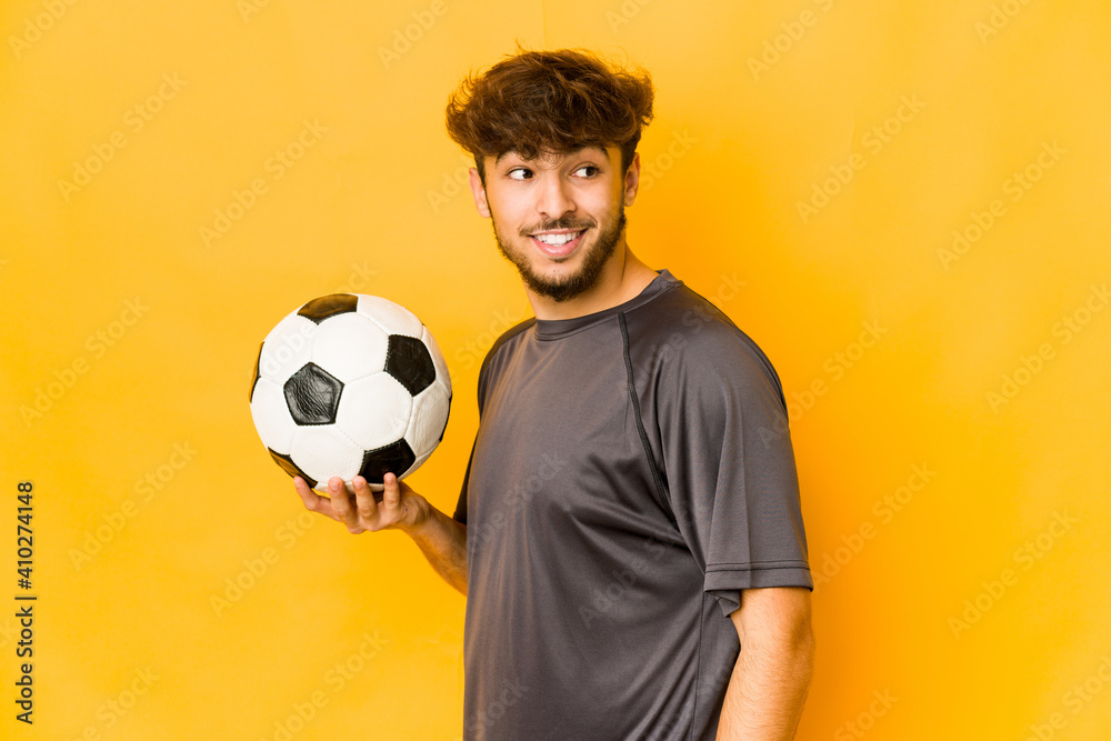 Young soccer player indian man looks aside smiling, cheerful and pleasant. Young soccer player indian man looks aside smiling, cheerful and pleasant.