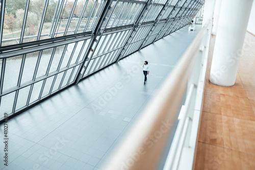 Young male entrepreneur walking by roof in office corridor photo