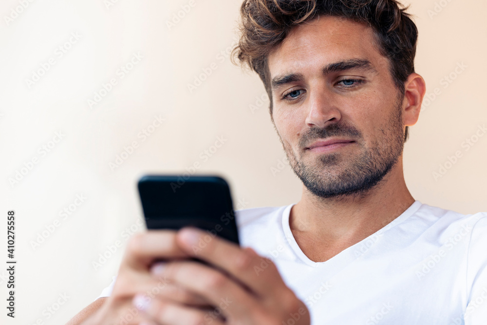 Serious man using smart phone at home Serious man using smart phone at home
