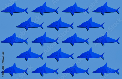 Blue dolphin's origami arranged on colored background photo