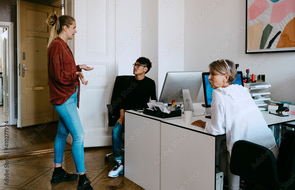 Male and female coworkers discussing in meeting at office Male and female coworkers discussing in meeting at office