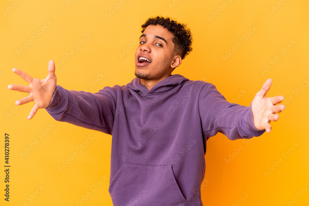 Young african american curly man isolated on purple feels confident giving a hug to the camera. Young african american curly man isolated on purple feels confident giving a hug to the camera.