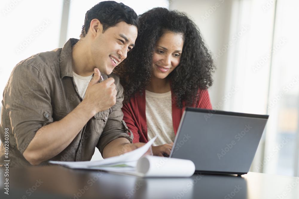 Smiling couple planning home ownership with model home Smiling couple planning home ownership with model home