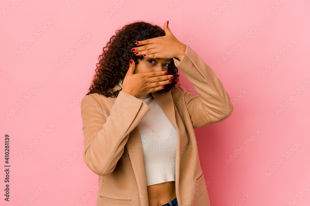 Young african american afro woman isolated blink at the camera through fingers, embarrassed covering face. Young african american afro woman isolated blink at the camera through fingers, embarrassed covering face.