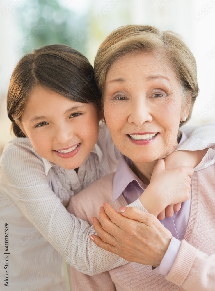 Granddaughter (8-9) embracing grandmother Granddaughter (8-9) embracing grandmother