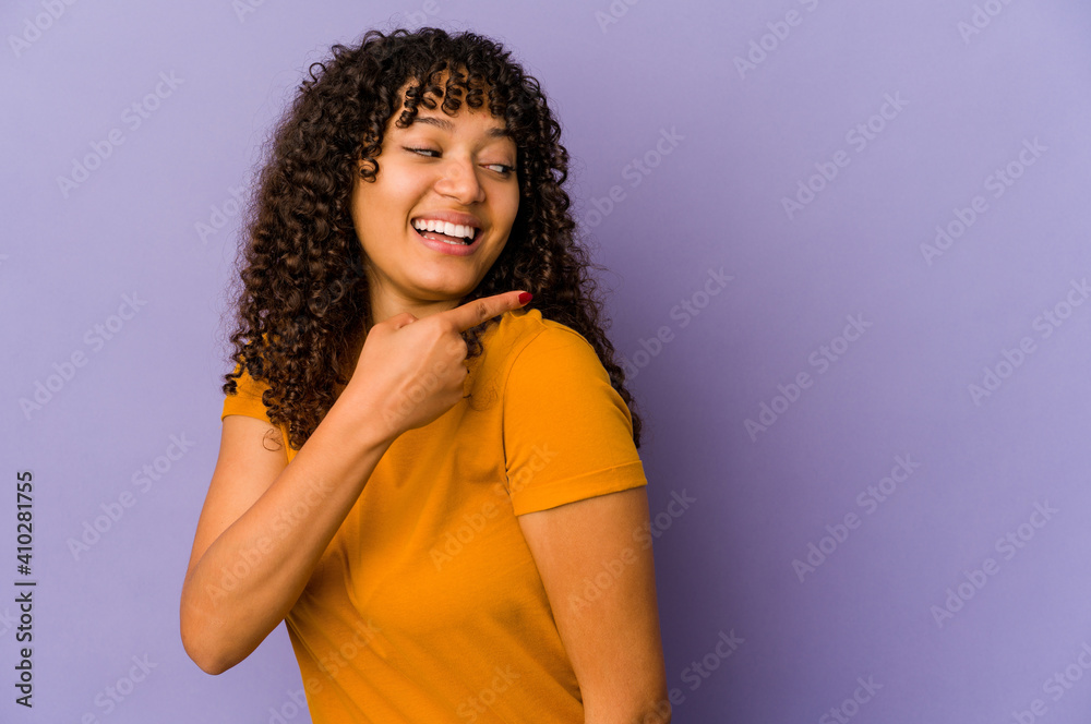 Young african american afro woman isolated looks aside smiling, cheerful and pleasant.
