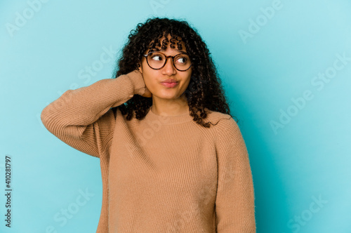 Foto Young african american afro woman isolated touching back of head, thinking and making a choice