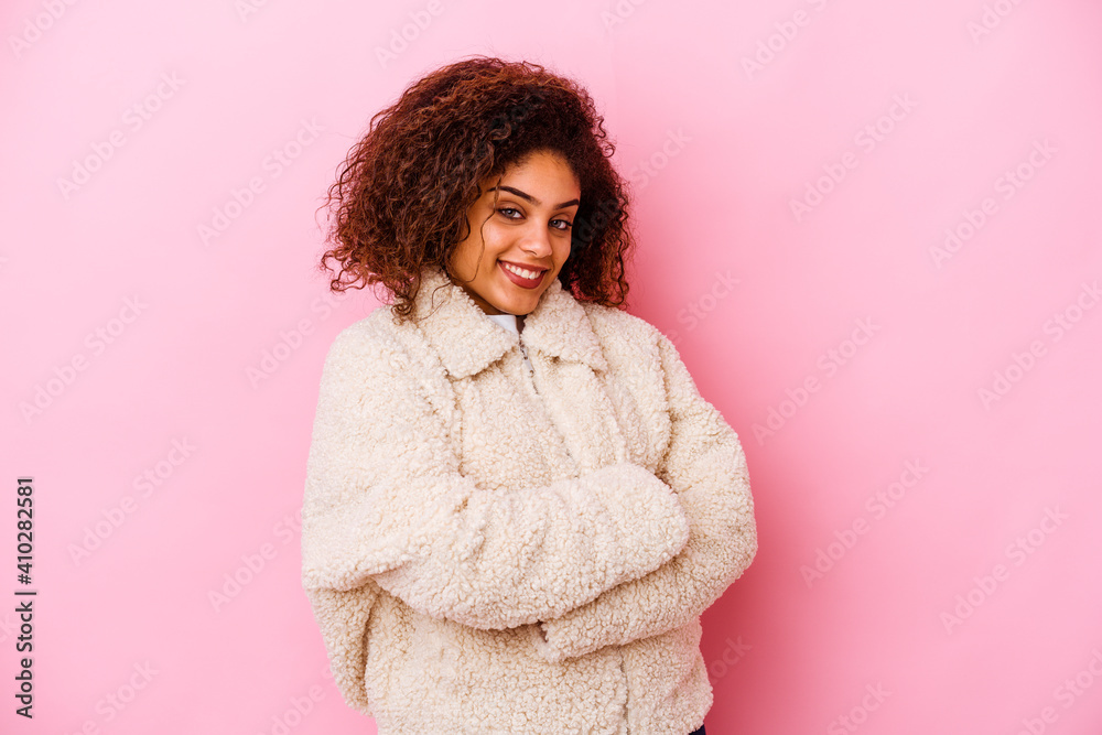 Young african american woman isolated on pink background who feels confident, crossing arms with determination. Young african american woman isolated on pink background who feels confident, crossing arms with determination.
