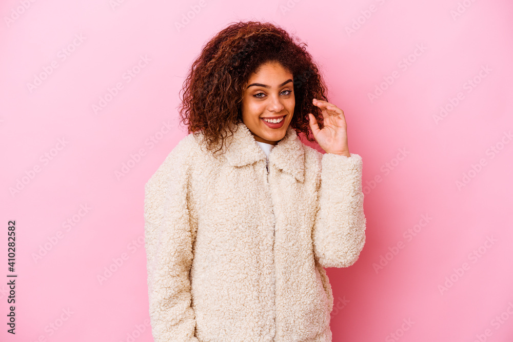 Young african american woman isolated on pink background laughing about something, covering mouth with hands. Young african american woman isolated on pink background laughing about something, covering mouth with hands.
