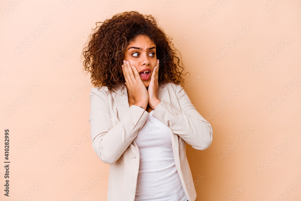Young african american woman isolated on beige background scared and afraid. Young african american woman isolated on beige background scared and afraid.