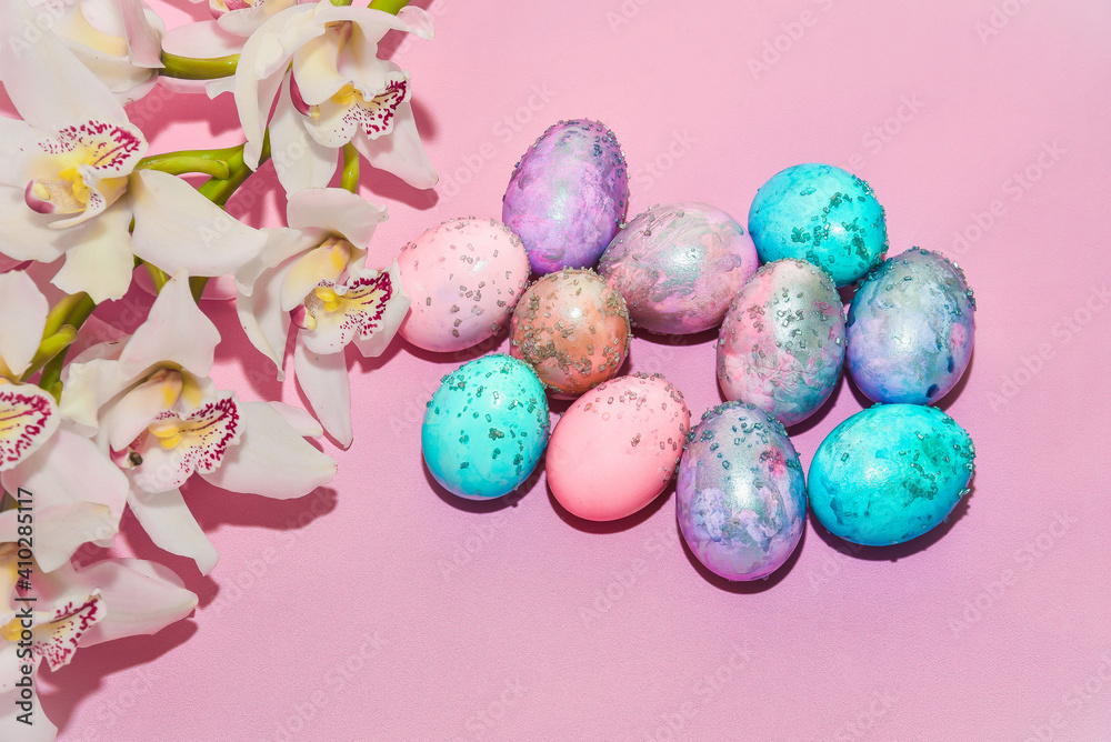 Fototapeta premium Easter eggs and orchid flower on a pink backdrop. Happy easter food and decorations, Orthodox easter celebration, spring theme, happy easter festive food 