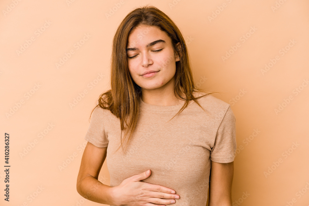 Obraz premium Young skinny caucasian teenager girl touches tummy, smiles gently, eating and satisfaction concept.