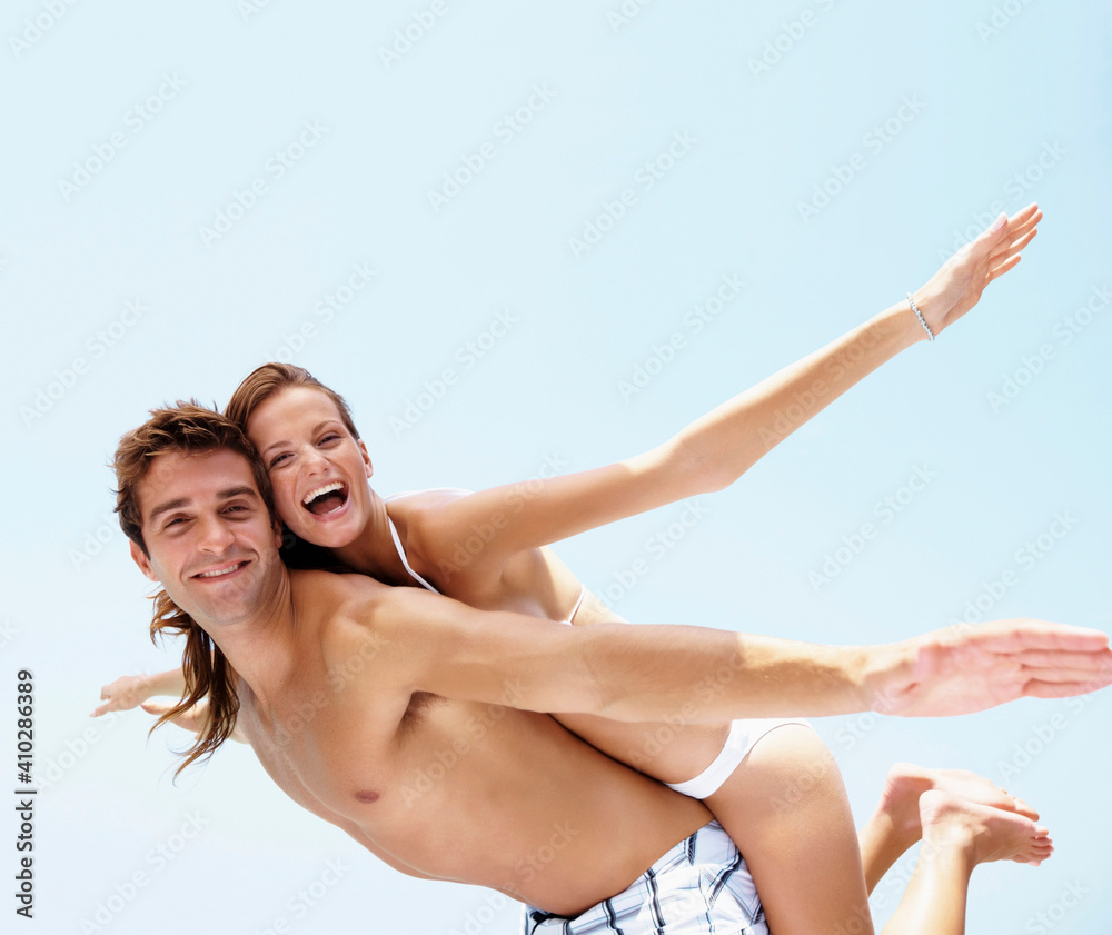 Young attractive couple enjoying summer holiday on beach