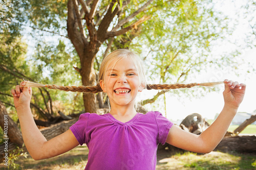 Little girl (4-5) holding out her pig tails as far as she can photo