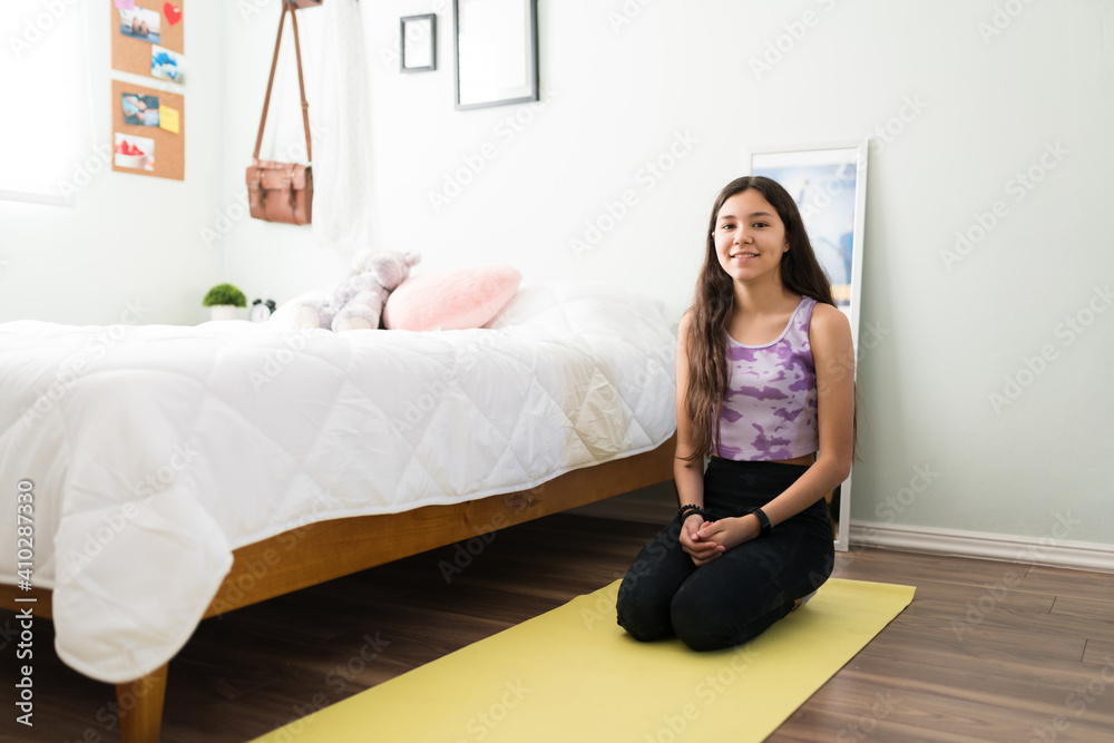 Portrait of a fit teenager exercising next to her bed Portrait of a fit teenager exercising next to her bed