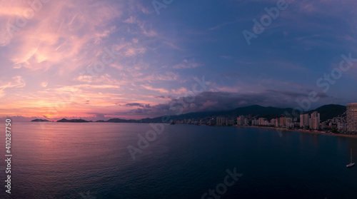 Fototapeta Naklejka Na Ścianę i Meble -  Beautiful sunset, aerial view of the beach, acapulco city seen from above. Travel and vacation concept. Colorful sunset on the beach