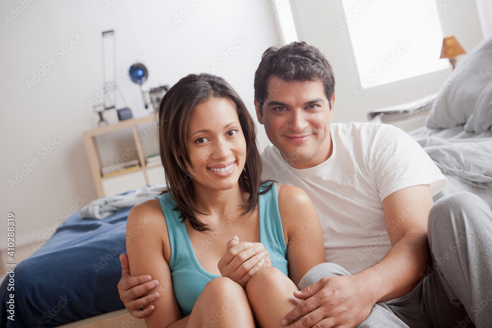Portrait of mid adult couple sitting on bedroom floor Portrait of mid adult couple sitting on bedroom floor