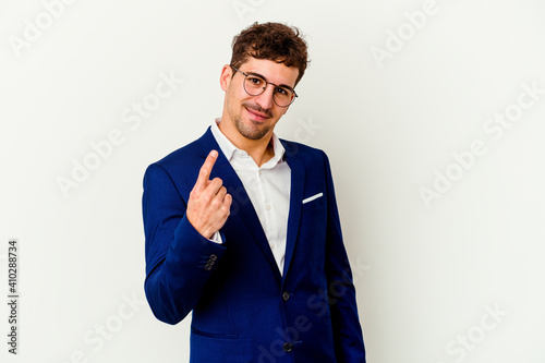 Young business caucasian man isolated on white background pointing with finger at you as if inviting come closer.