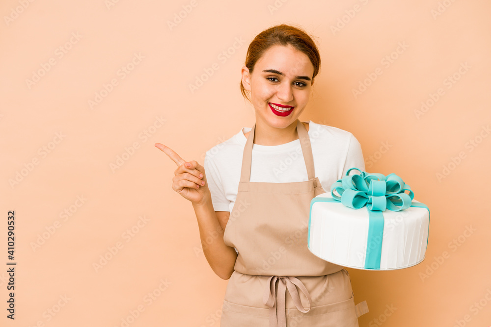Young skinny arab pastry chef woman smiling and pointing aside, showing something at blank space. Young skinny arab pastry chef woman smiling and pointing aside, showing something at blank space.