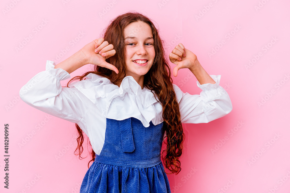 Naklejka premium Little caucasian girl isolated on pink background feels proud and self confident, example to follow.