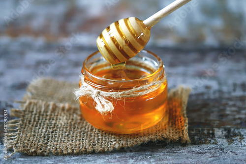 Selective focus. Jar of honey. Honey stick. Transparent honey. Liquid honey.