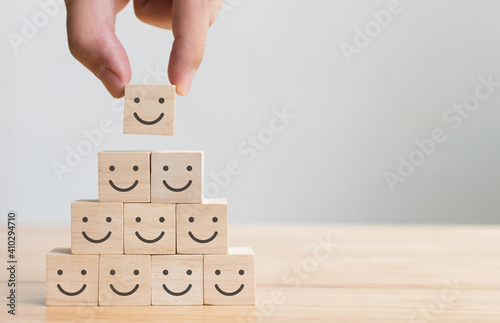 Hand putting wooden cube block shape with icon face smiley, The best excellent business services rating customer experience, Satisfaction survey concept