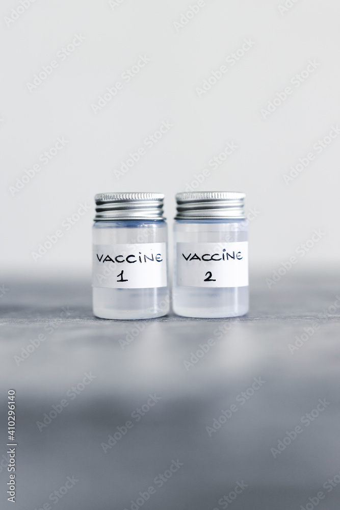 covid-19 vaccine race and immunisation against the pandemic, ampoules with Vaccine 1 and Vaccine 2 labels side by side