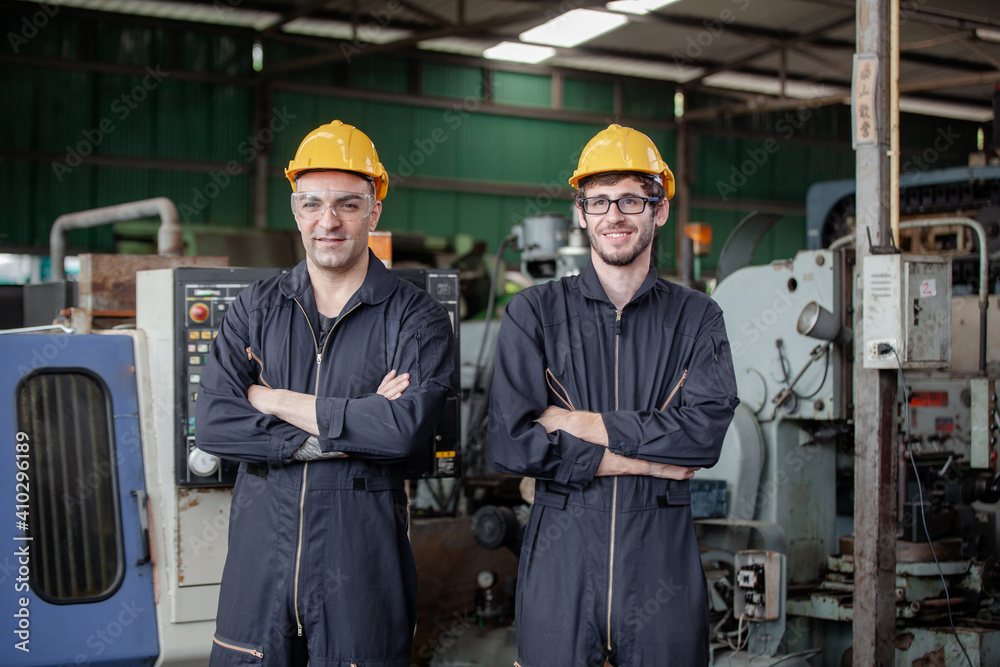 Portrait of a worker in a factory. Portrait of industrial worker indoors in factory. Young technician with hard hat. Portrait of a worker in a factory. Portrait of industrial worker indoors in factory. Young technician with hard hat.