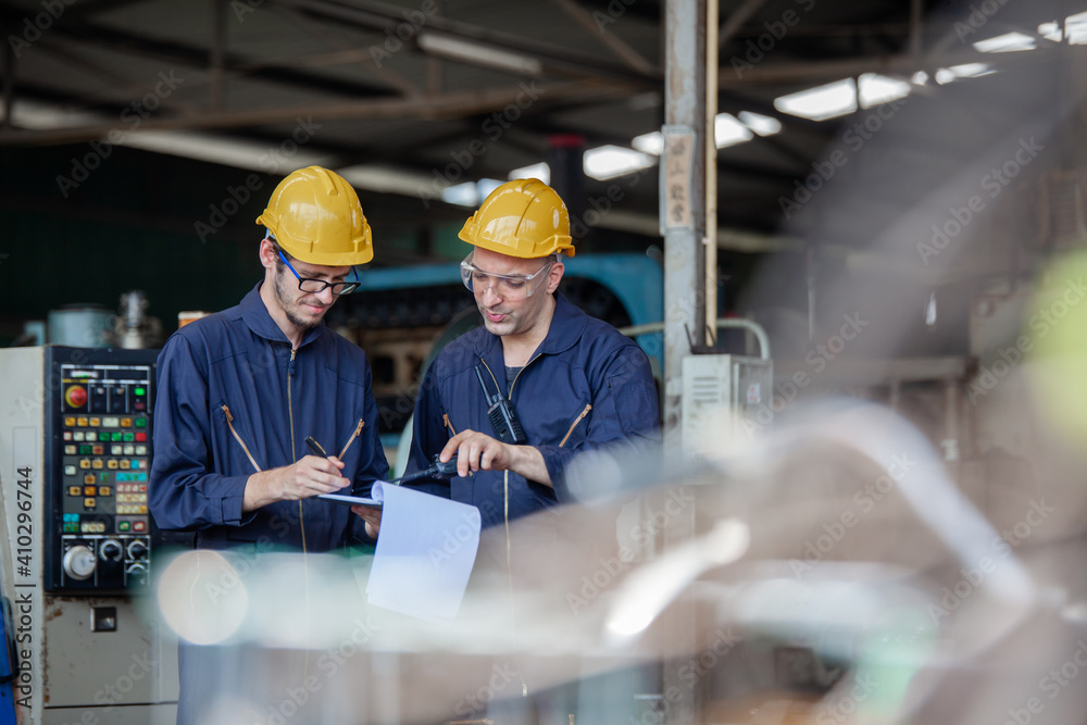 Portrait of a worker in a factory. Portrait of industrial worker indoors in factory. Young technician with hard hat.