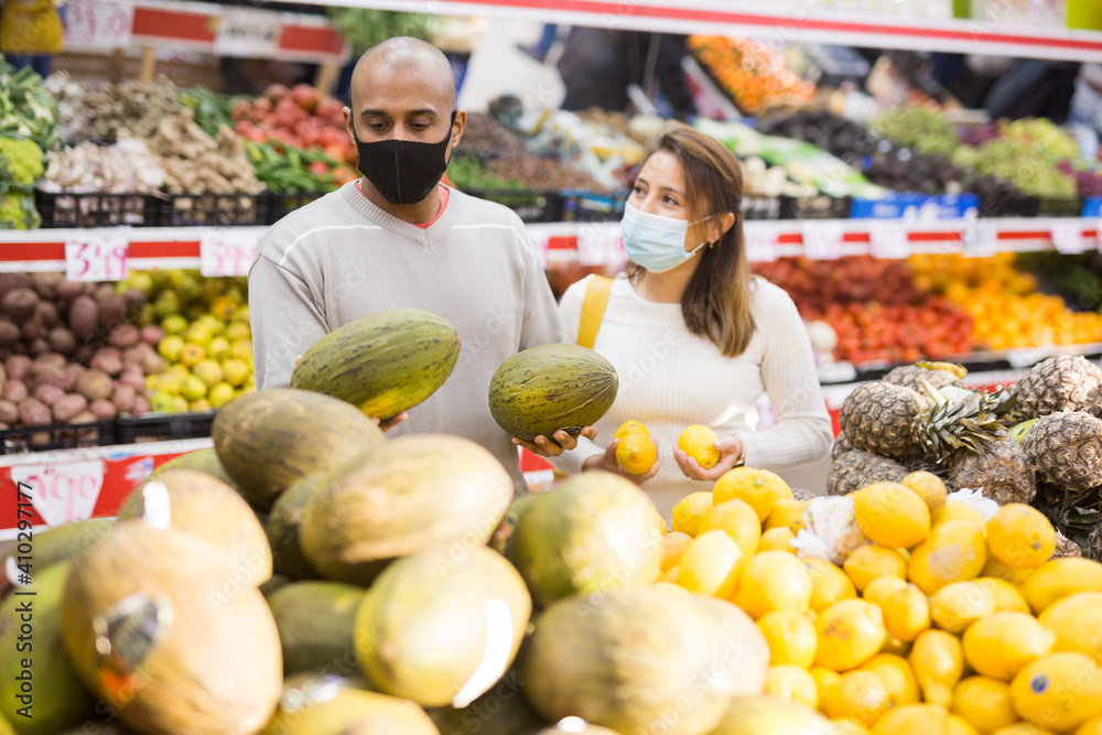 Portrait of latin couple wearing medical masks in supermarket during COVID-19 quarantine