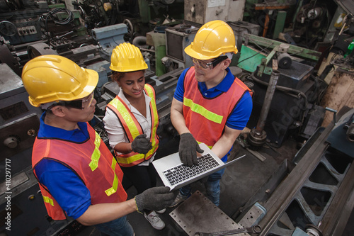 worker Industrial Engineers Talk with Factory Worker while Using Laptop. industrial worker is working. technician engineer and mentor checking process. machine metalworking industry concept copyspace