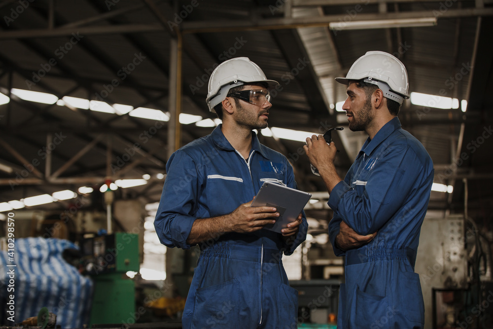 Two people working. Male Industrial Engineers Talk with Factory Worker while Using tablet. Two people working. Male Industrial Engineers Talk with Factory Worker while Using tablet.