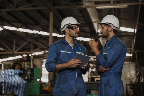 Two people working. Male Industrial Engineers Talk with Factory Worker while Using tablet.