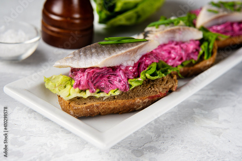 Delicious sandwiches with herring, beetroot and green salad leaves. Herring is a source of omega 3 fats. Healthy for brain and mental clarity. Brain foods concept. Home comfort cooking