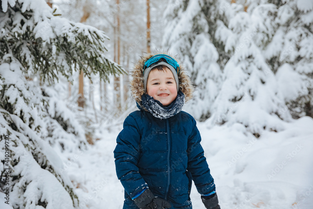 child playing in snow. Boy in winter clothes. Child in the forest. Winter in forest child playing in snow. Boy in winter clothes. Child in the forest. Winter in forest