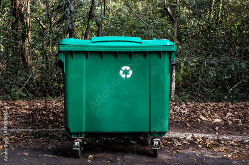Large green recycle bin on the street of a park in Brazil