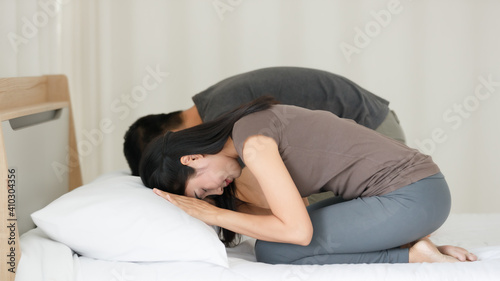 Man and woman Buddhist sitting on bed in the bedroom and pay homage, praying in Buddhism religion style together. The idea for faith and trust in religion and calm of mind