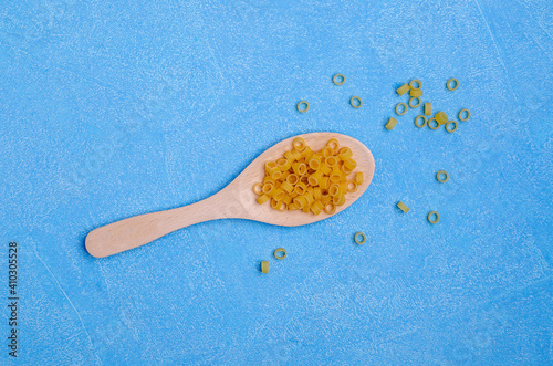 Dry pasta in a wooden spoon photo