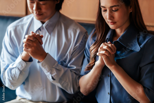 Close up hand. Asian Christian woman and man holding hands in praying for Jesus' blessings to show love and confession of their sins according to the Christian faith. Concept giving love faith..