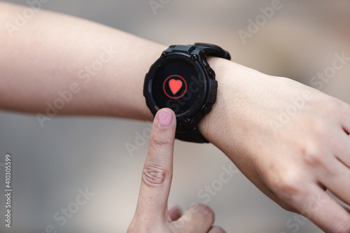 close up hand of woman point finger at smartwatch checking measuring heart rate after exercise.