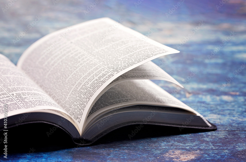 Obraz premium Bible Open on a Rustic Blue Wooden Table