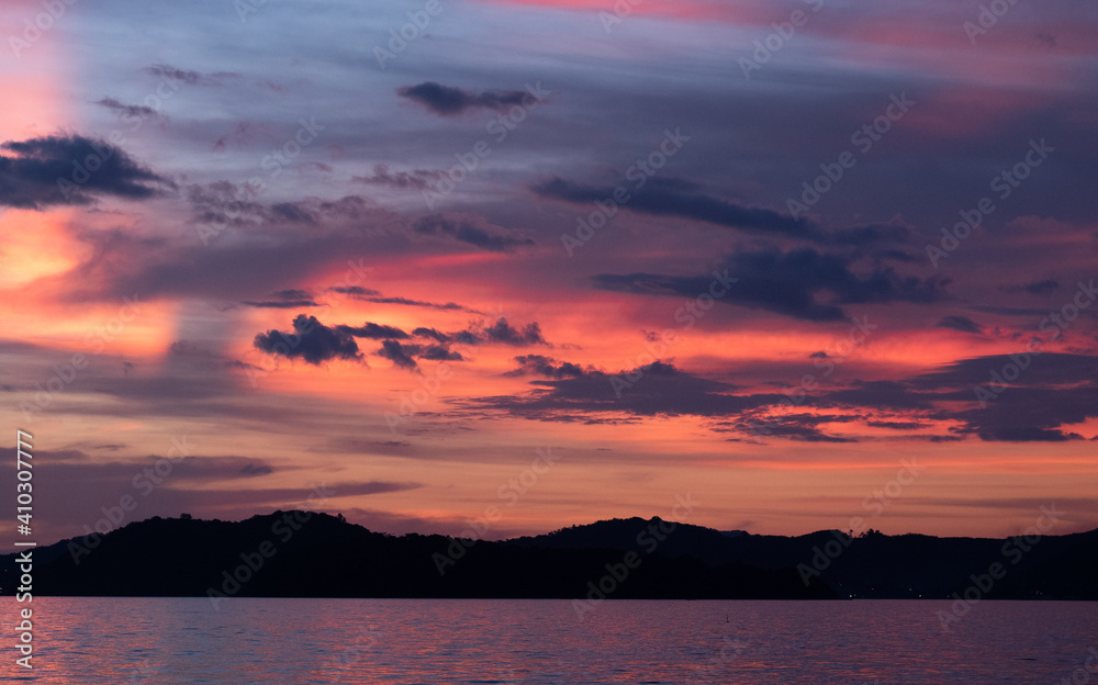 Panoramic view of sunset with orange and blue purple sky with cloud above the sea