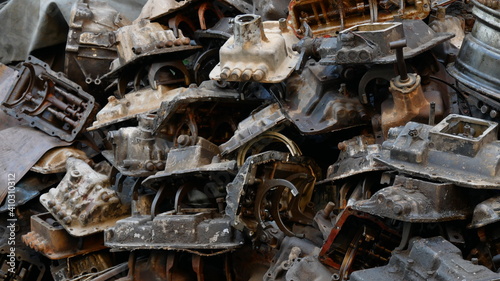 Pile of old machine parts in second hand machinery shop, background of damage and rusty old car machine