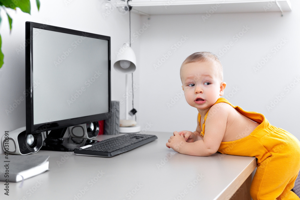 Caucasian funny little baby boy exploring computer, monitor and keyboard Caucasian funny little baby boy exploring computer, monitor and keyboard