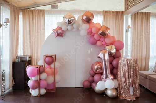 Photo zone to celebrate the anniversary. Children's decorative photo zone in pink and white colors with a lot of air balloons with white copy space. Decorations for a One year old Girls Birthday party