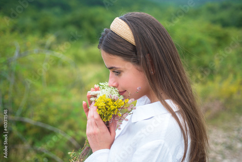 Woman in field. Healthy lifestyle. Carefree girl in meadow with wildflowers.